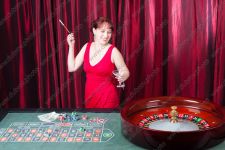 Смеющаяся молодая женщина играет в рулетку в казино